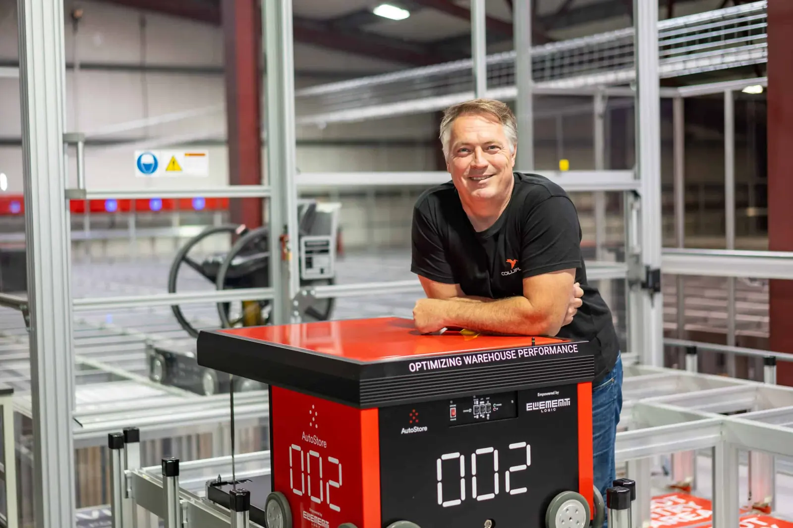 Rune Wright Lia, daglig leder i Colliflow, lent mot en AutoStore-robot